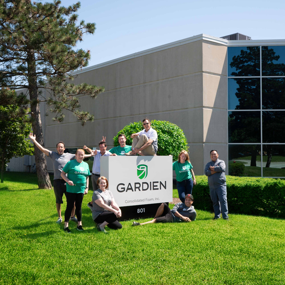 Entire Gardien team in front of office building by Gardien sign