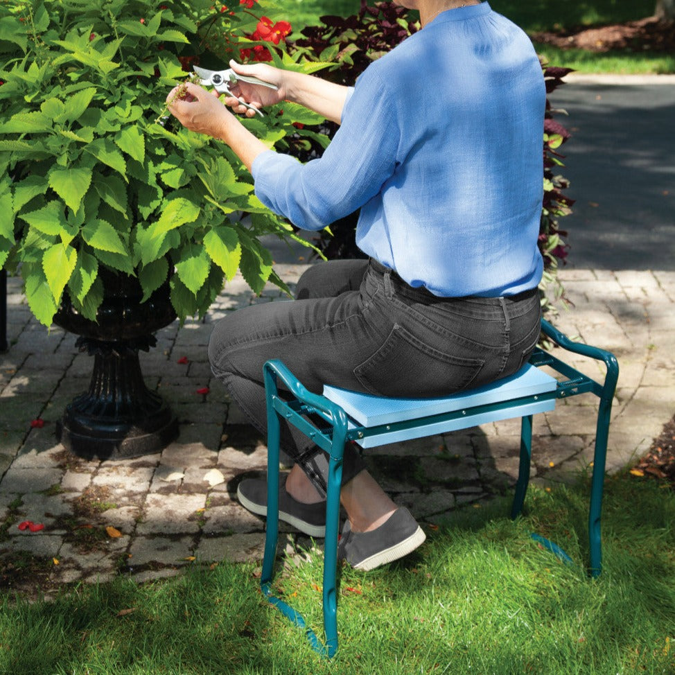 Garden Kneeler in use with woman using as seat trimming plants